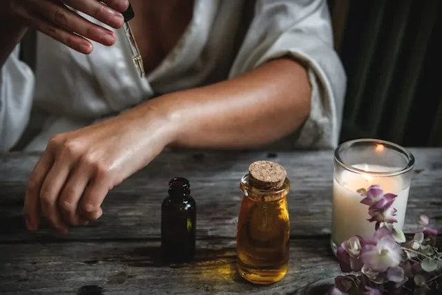 Woman massaging red ginger essential oil into her arm